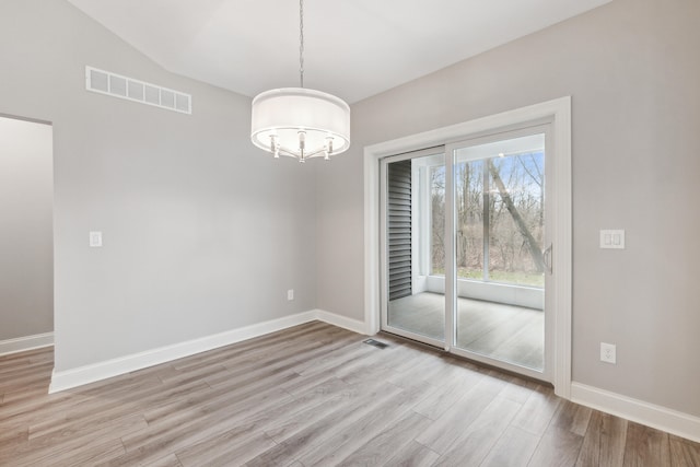 unfurnished dining area featuring light wood-type flooring, vaulted ceiling, and a notable chandelier