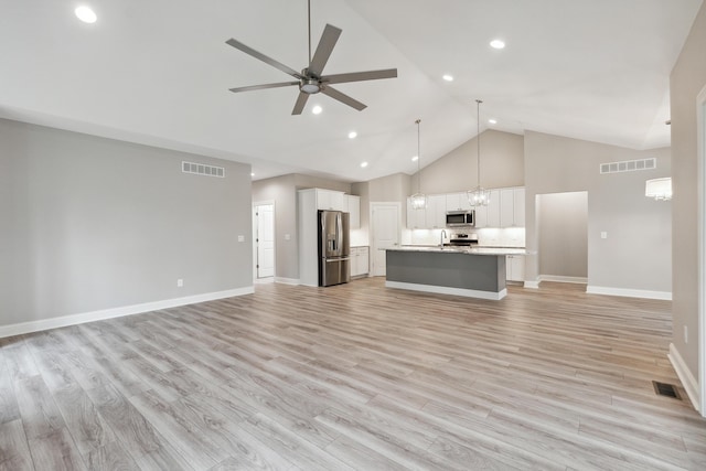 1140 Lochaven Cir Unit 10B, Hillsdale, MI 49242 - unfurnished living room with high vaulted ceiling, ceiling fan, recessed lighting, baseboards, and a chandelier