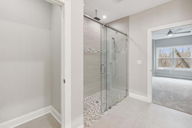 bathroom with tile patterned floors, ceiling fan, and a shower with door