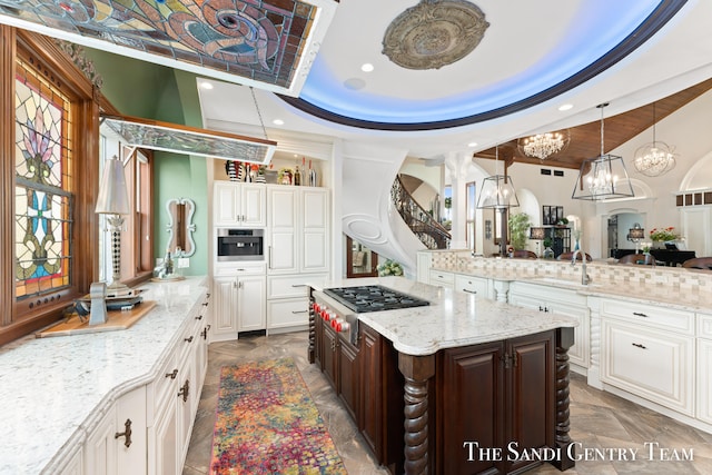 kitchen featuring white cabinetry, a center island, a raised ceiling, dark brown cabinets, and appliances with stainless steel finishes