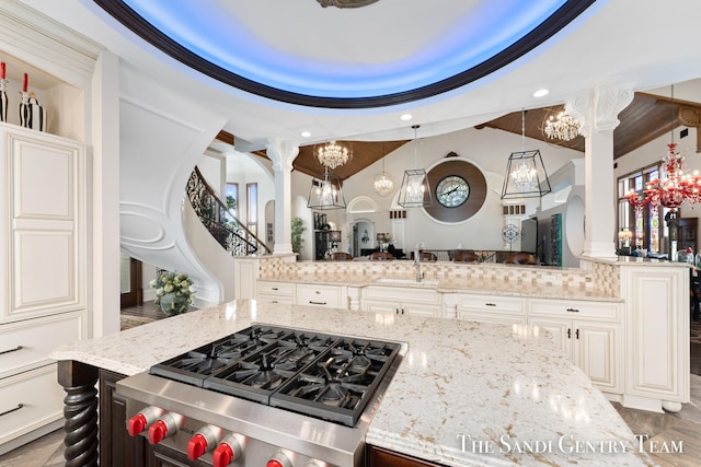 kitchen with pendant lighting, backsplash, and light stone counters