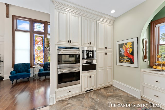 kitchen with double oven and dark wood-type flooring