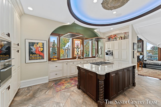 kitchen with a kitchen island, dark brown cabinetry, stainless steel appliances, and a wealth of natural light