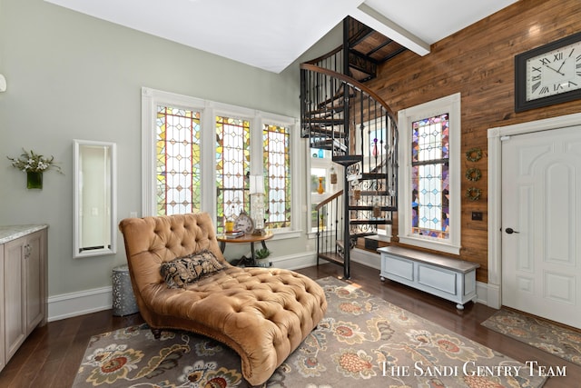 sitting room with vaulted ceiling with beams, dark hardwood / wood-style floors, and wooden walls