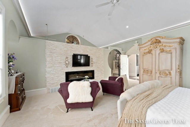 carpeted bedroom featuring a stone fireplace, ceiling fan, and lofted ceiling