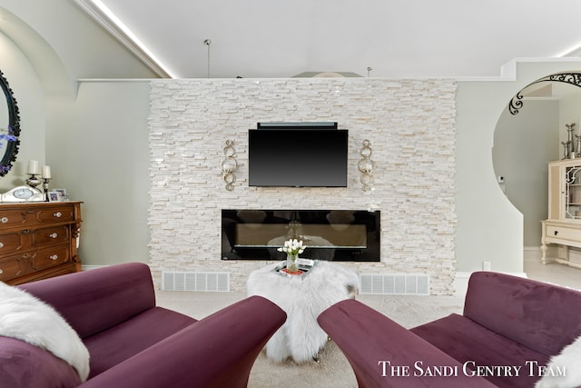 living room featuring crown molding, a fireplace, and carpet floors