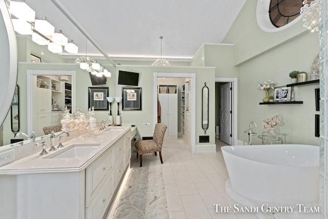 bathroom featuring a washtub, tile patterned flooring, a chandelier, lofted ceiling, and vanity