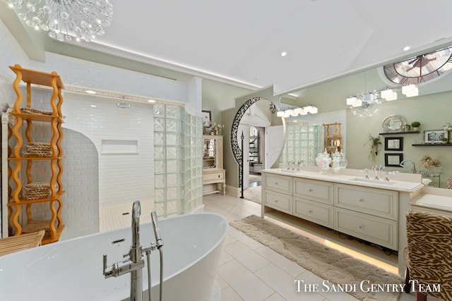 bathroom featuring tile patterned flooring, vanity, shower with separate bathtub, and an inviting chandelier