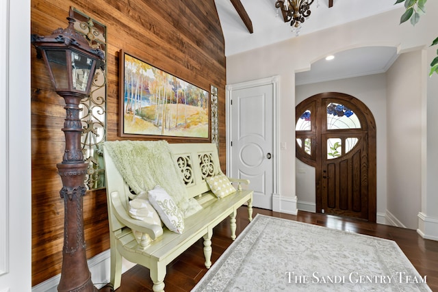 entrance foyer featuring wood walls, dark hardwood / wood-style flooring, and crown molding