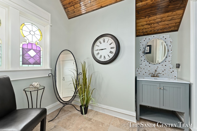 living area featuring wood ceiling, sink, and vaulted ceiling