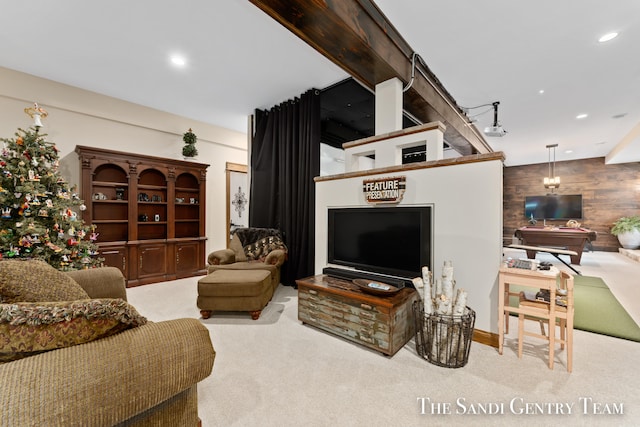 living room featuring beam ceiling, wood walls, and light carpet