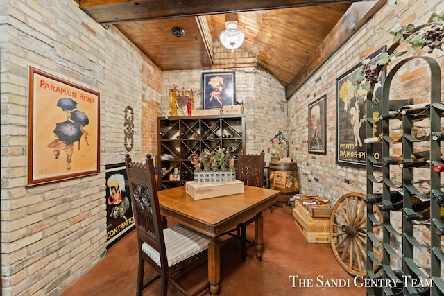 wine area with brick wall, concrete floors, lofted ceiling, and wood ceiling