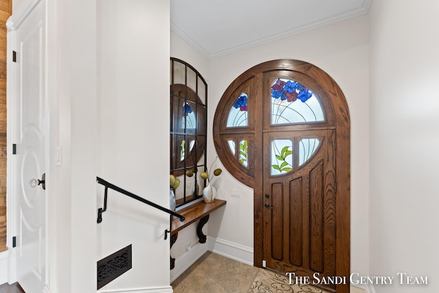 foyer entrance with light tile patterned floors and ornamental molding