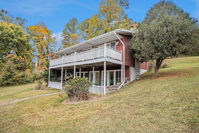 rear view of house with a deck and a lawn