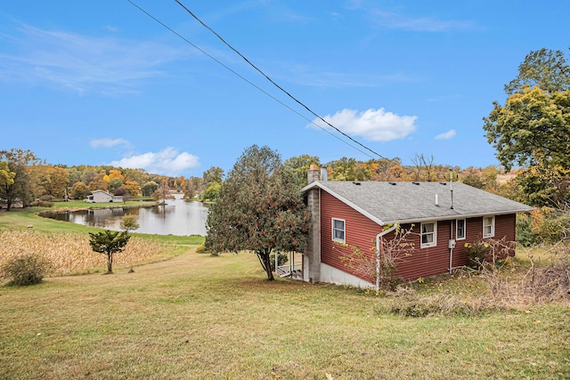 view of side of home with a lawn and a water view