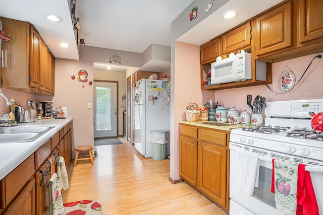 kitchen featuring white appliances, light hardwood / wood-style floors, and sink