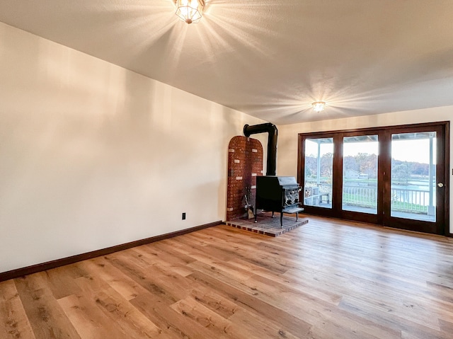 unfurnished living room featuring a wood stove and hardwood / wood-style flooring