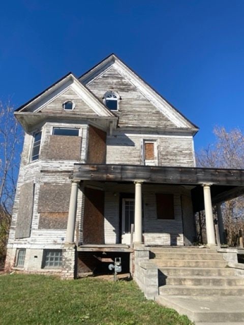 view of front of house with covered porch and a front lawn