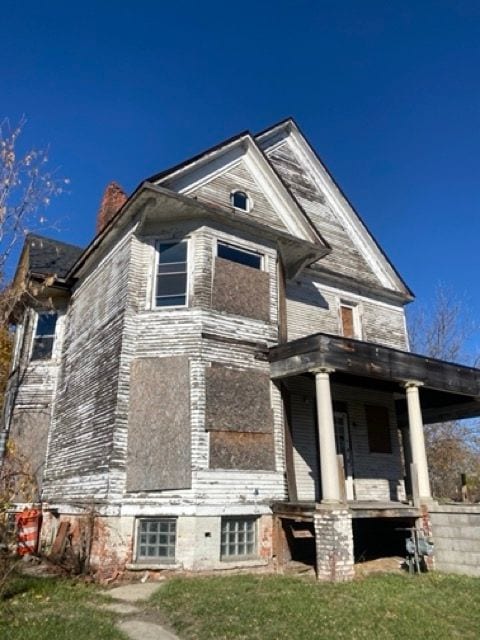 100 Pingree St, Detroit, MI 48202 - view of front of home with a porch, a chimney, and a front yard