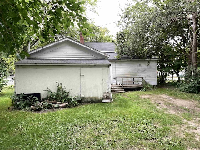 415 S Franklin, Mount Pleasant, MI 48858 - view of property exterior featuring a wooden deck, a lawn, a chimney, and a shingled roof