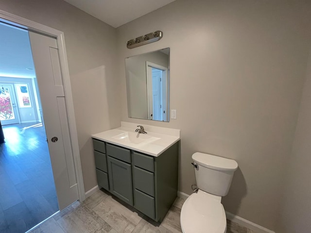 bathroom with hardwood / wood-style flooring, vanity, and toilet