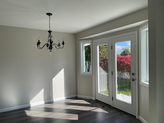 doorway featuring dark hardwood / wood-style floors and an inviting chandelier