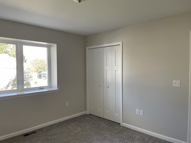 260 Windemere Pl, West Branch, MI 48661 - unfurnished bedroom featuring dark colored carpet, baseboards, and a closet