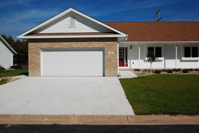 260 Windemere Pl, West Branch, MI 48661 - single story home with brick siding, driveway, an attached garage, a front yard, and a porch