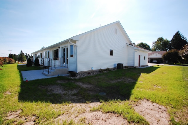 view of side of home with a lawn and central air condition unit