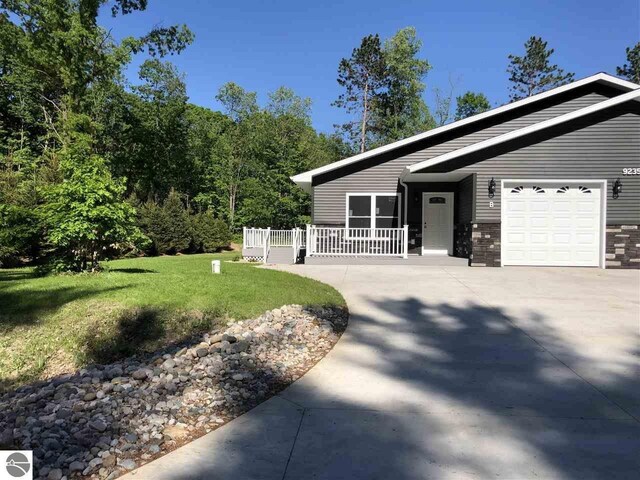 00 Sockeye Dr, Farwell, MI 48622 - view of front of house with concrete driveway, a front yard, and a garage