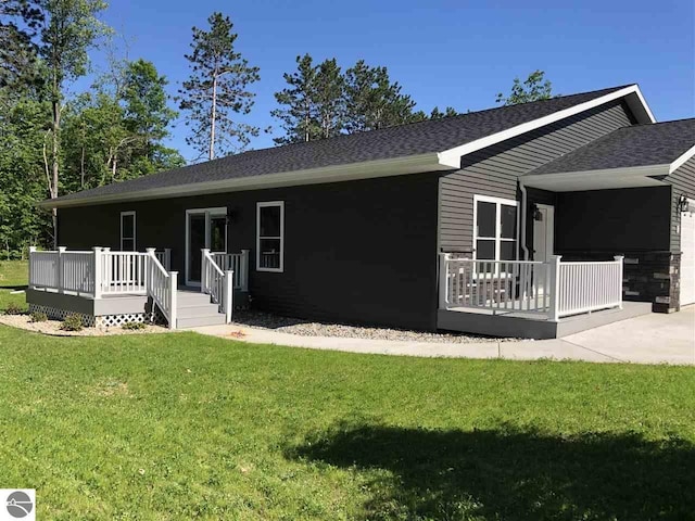 00 Sockeye Dr, Farwell, MI 48622 - rear view of property featuring a wooden deck, a yard, an attached garage, and roof with shingles