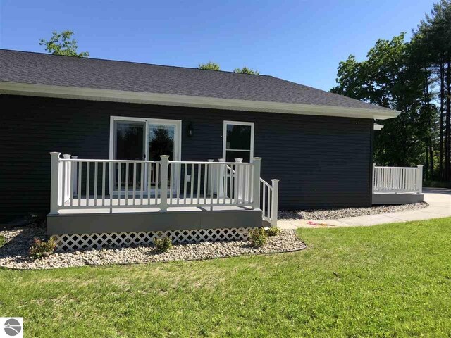 00 Sockeye Dr, Farwell, MI 48622 - back of house featuring a wooden deck, a lawn, and a shingled roof