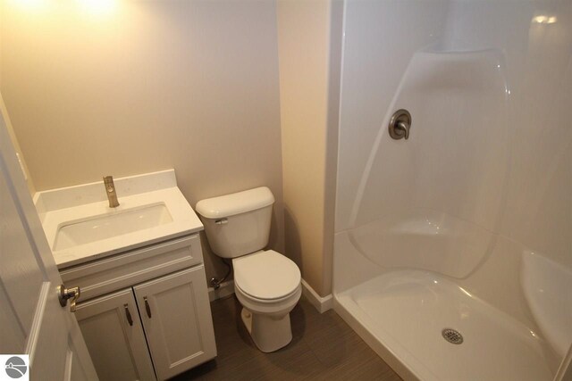 00 Sockeye Dr, Farwell, MI 48622 - full bathroom featuring toilet, vanity, a shower, baseboards, and wood finished floors