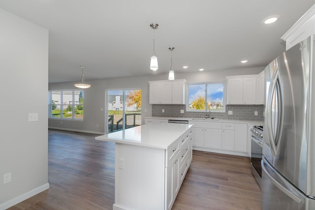 kitchen featuring a kitchen island, white cabinets, dark wood-type flooring, and appliances with stainless steel finishes