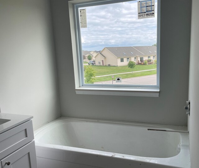 bathroom with vanity and a bath