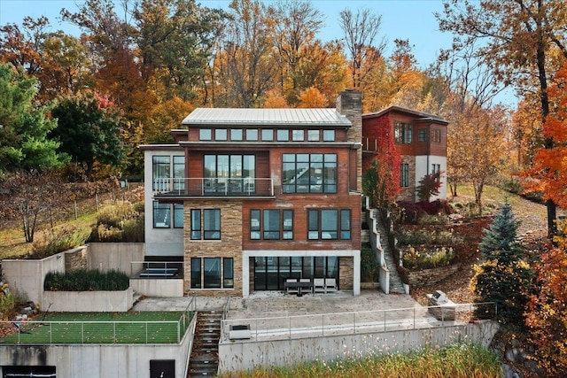 back of property with a balcony and a patio area