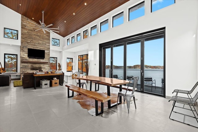 tiled dining area featuring ceiling fan, wood ceiling, and high vaulted ceiling