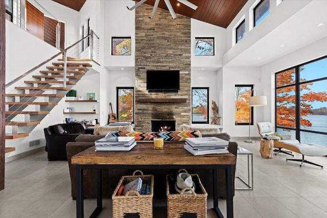 living room with a large fireplace, wood ceiling, and high vaulted ceiling