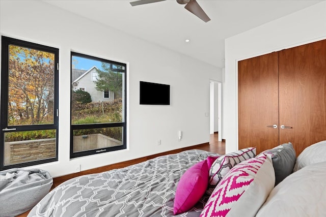 bedroom featuring hardwood / wood-style floors, ceiling fan, and a closet