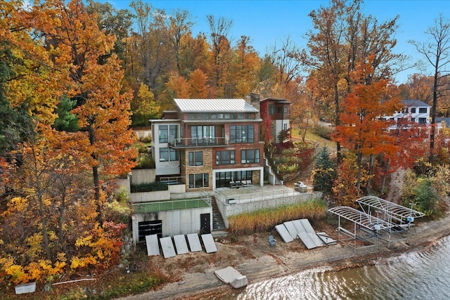 back of property featuring a balcony and a water view