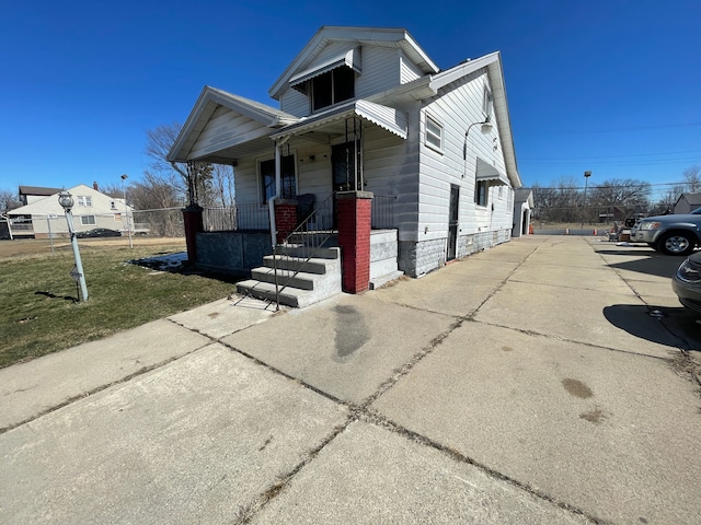 view of front of property featuring covered porch and a front lawn