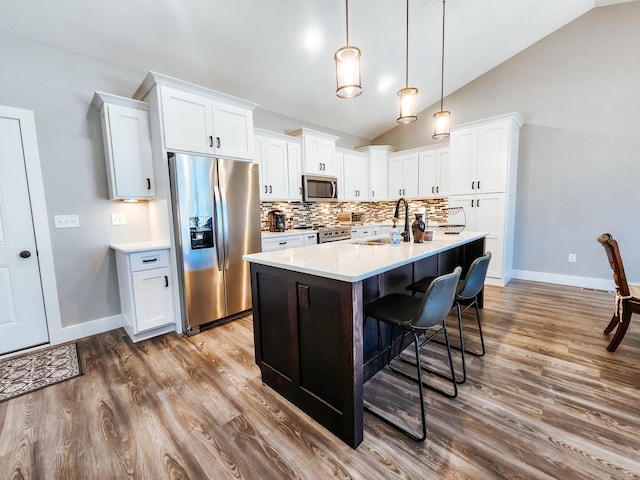 kitchen featuring white cabinetry, sink, lofted ceiling, and appliances with stainless steel finishes