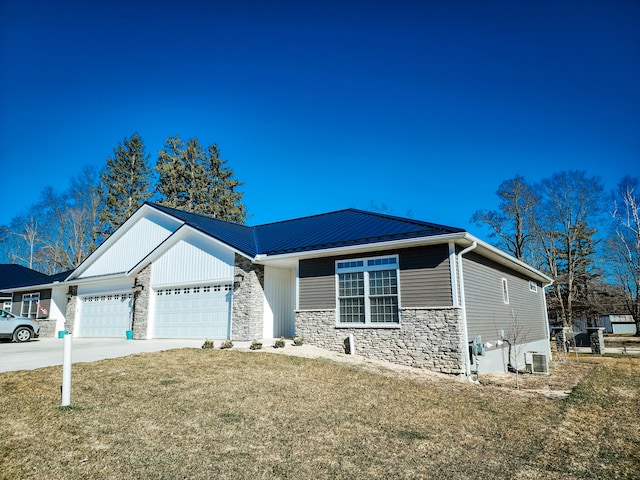 view of front of property with central AC, a front yard, and a garage