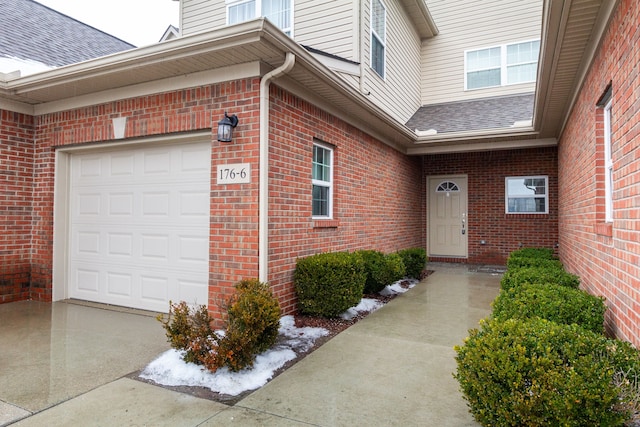 176 Sea Breeze Dr Unit 6, Detroit, MI 48214 - doorway to property featuring brick siding, a garage, driveway, and roof with shingles