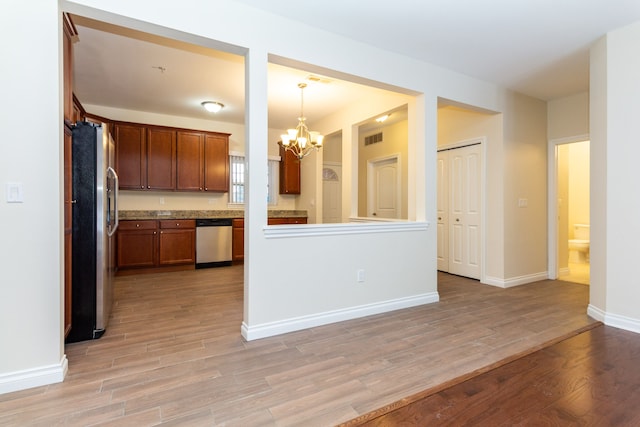 176 Sea Breeze Dr Unit 6, Detroit, MI 48214 - kitchen featuring appliances with stainless steel finishes, a chandelier, light wood-type flooring, baseboards, and decorative light fixtures