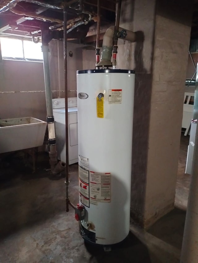 utility room featuring water heater, sink, and washer / dryer