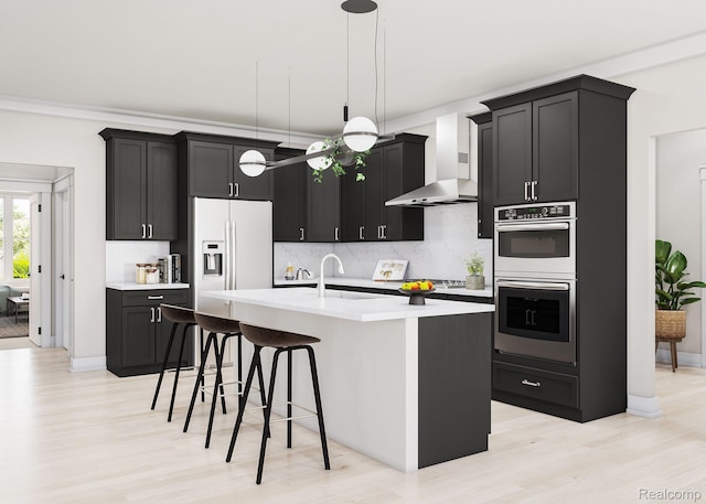 835 Coldrose Way, Canton, MI 48187 - kitchen with stainless steel double oven, high end white fridge, wall chimney exhaust hood, dark cabinetry, and light wood-style flooring