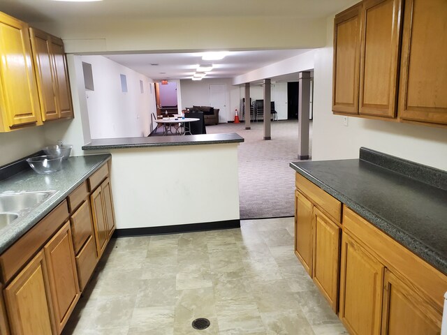 20331 Outer Dr, Dearborn, MI 48124 - kitchen featuring open floor plan, dark countertops, a peninsula, brown cabinets, and light carpet