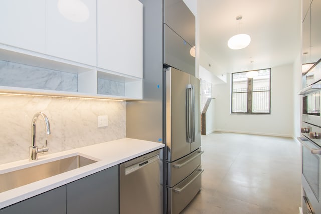 kitchen featuring decorative light fixtures, backsplash, stainless steel appliances, and gray cabinetry