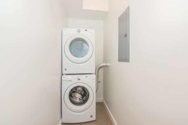 laundry area featuring electric panel and stacked washing maching and dryer